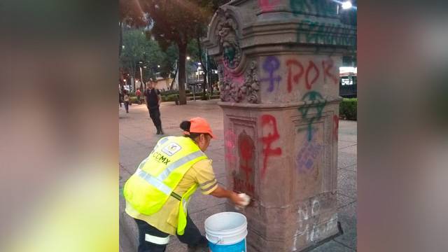 Mujeres limpian pintas tras la marcha de ayer