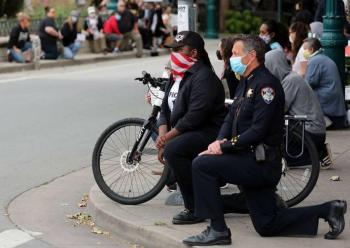 Polic&iacute;as se solidarizan con manifestantes y se arrodillan ante ellos en Estados Unidos