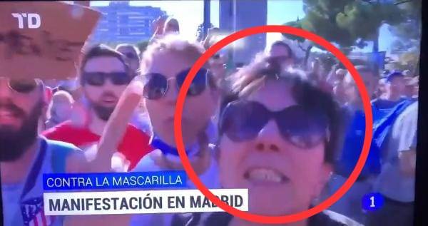 Mujer escupe a camar&oacute;grafo durante protesta contra el uso de cubrebocas en Espa&ntilde;a