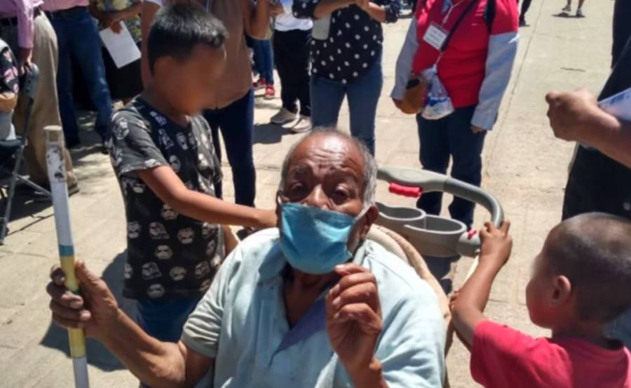 En carreola para beb&eacute;, ni&ntilde;os llevan a vacunar a su abuelo en Oaxaca