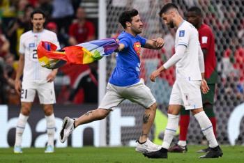 Un hombre con una bandera arco&iacute;ris entra en la cancha del Portugal-Uruguay