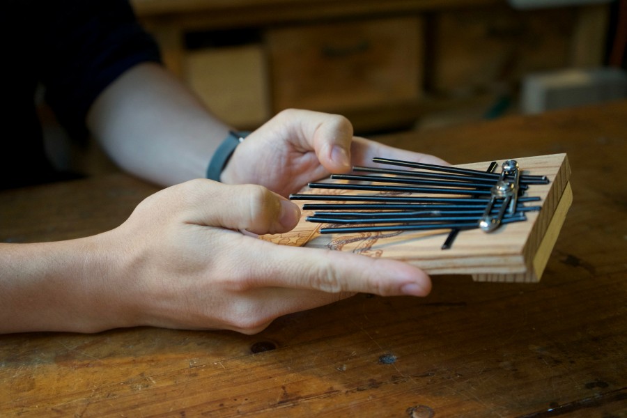 Con paraguas, Kevin Cheung elabora pianos de pulgar